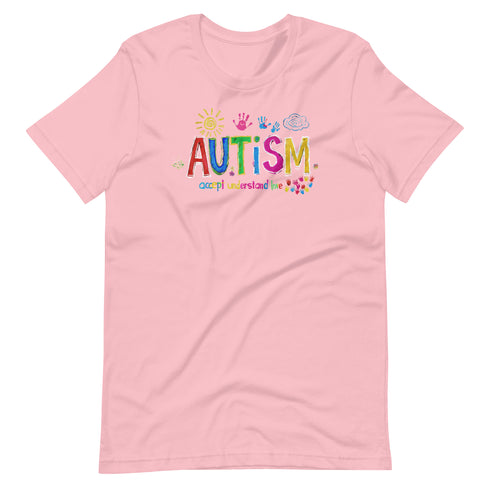 A pink t-shirt with a colorful autism awareness design. "Autism" is surrounded by colorful, childlike drawings with "accept understand love" underneath.