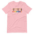 A pink t-shirt with a colorful "Everyone is welcome here" design. Above the phrase, multicultural hands are shown with hearts on them.